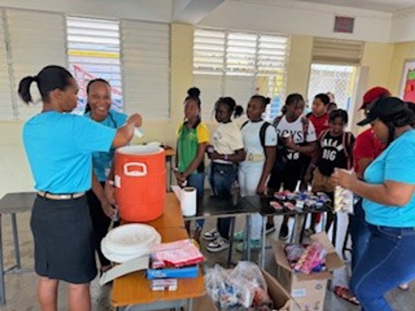 Volunteers sharing refreshments with young campers